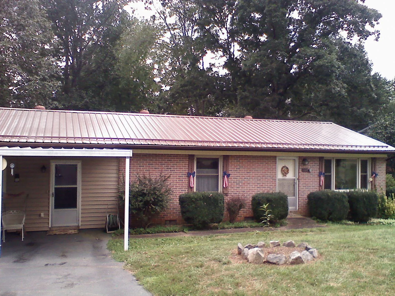 Bronze metal roof and carport on a brick ranch home — Roof Repair work by our crew in Dauphin Island