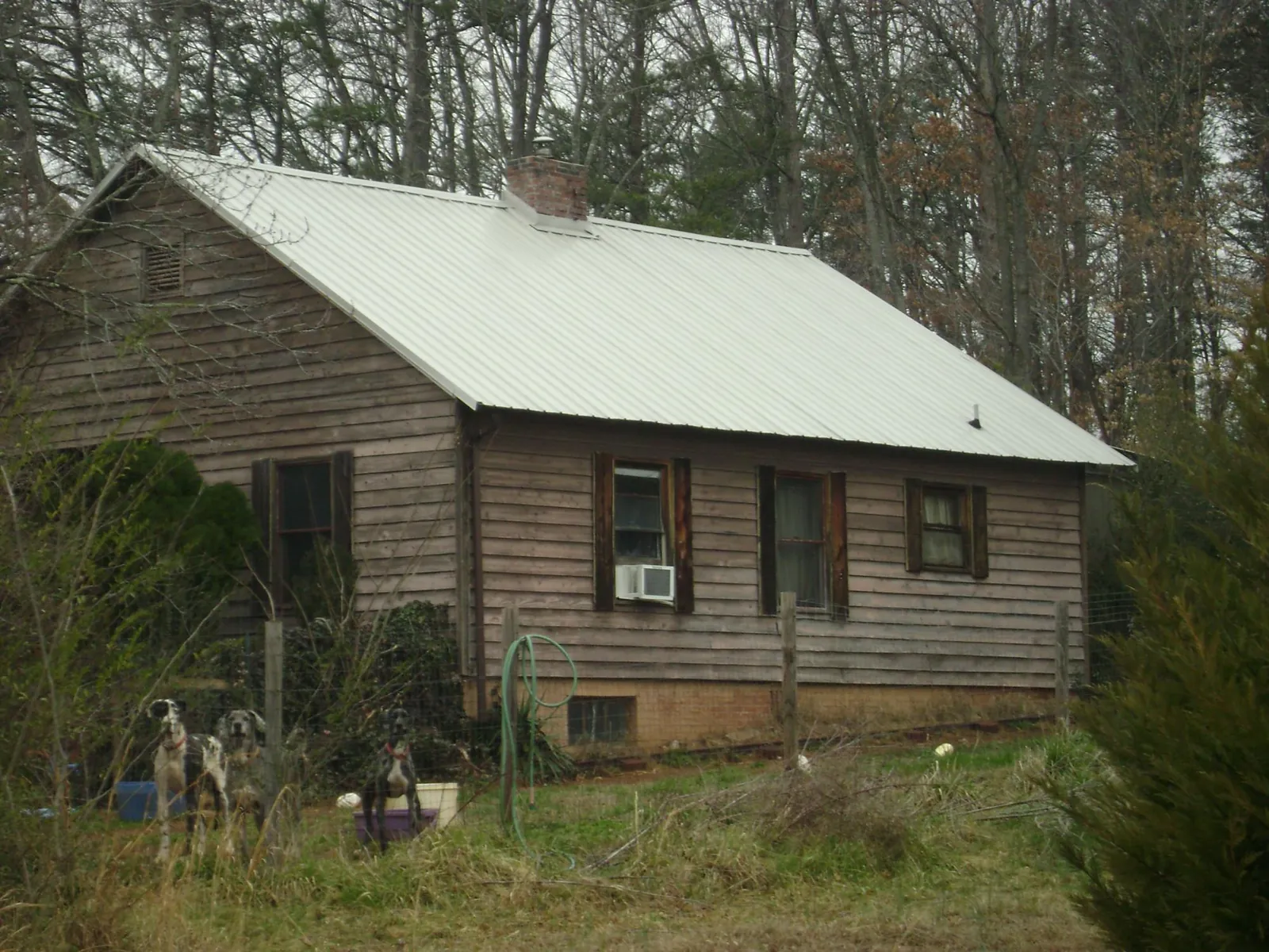 White metal roof on an old wood sided farmhouse, from a Metal Roof Installation job in Dauphin Island